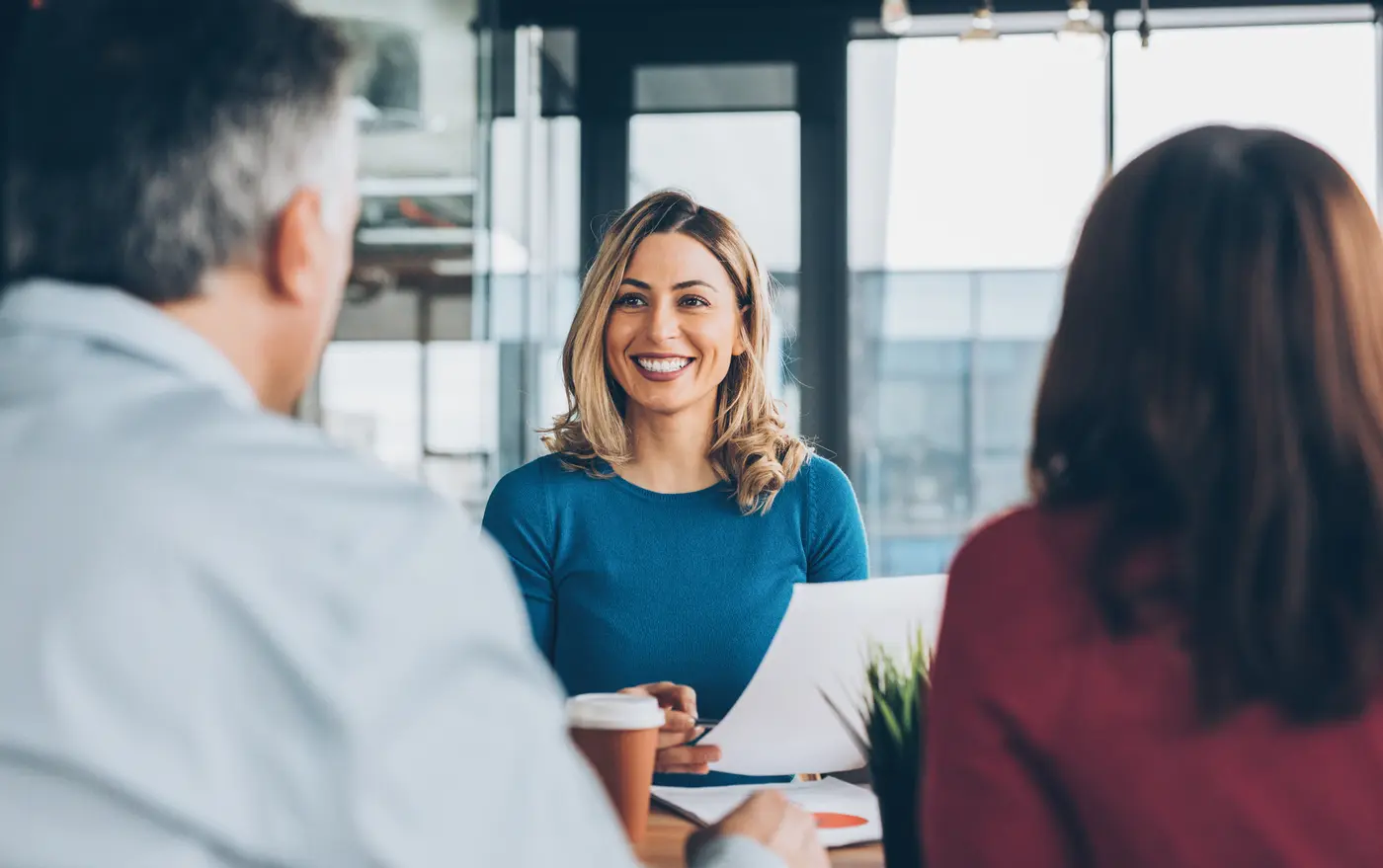 Woman discussing with three others during a meeting. 
