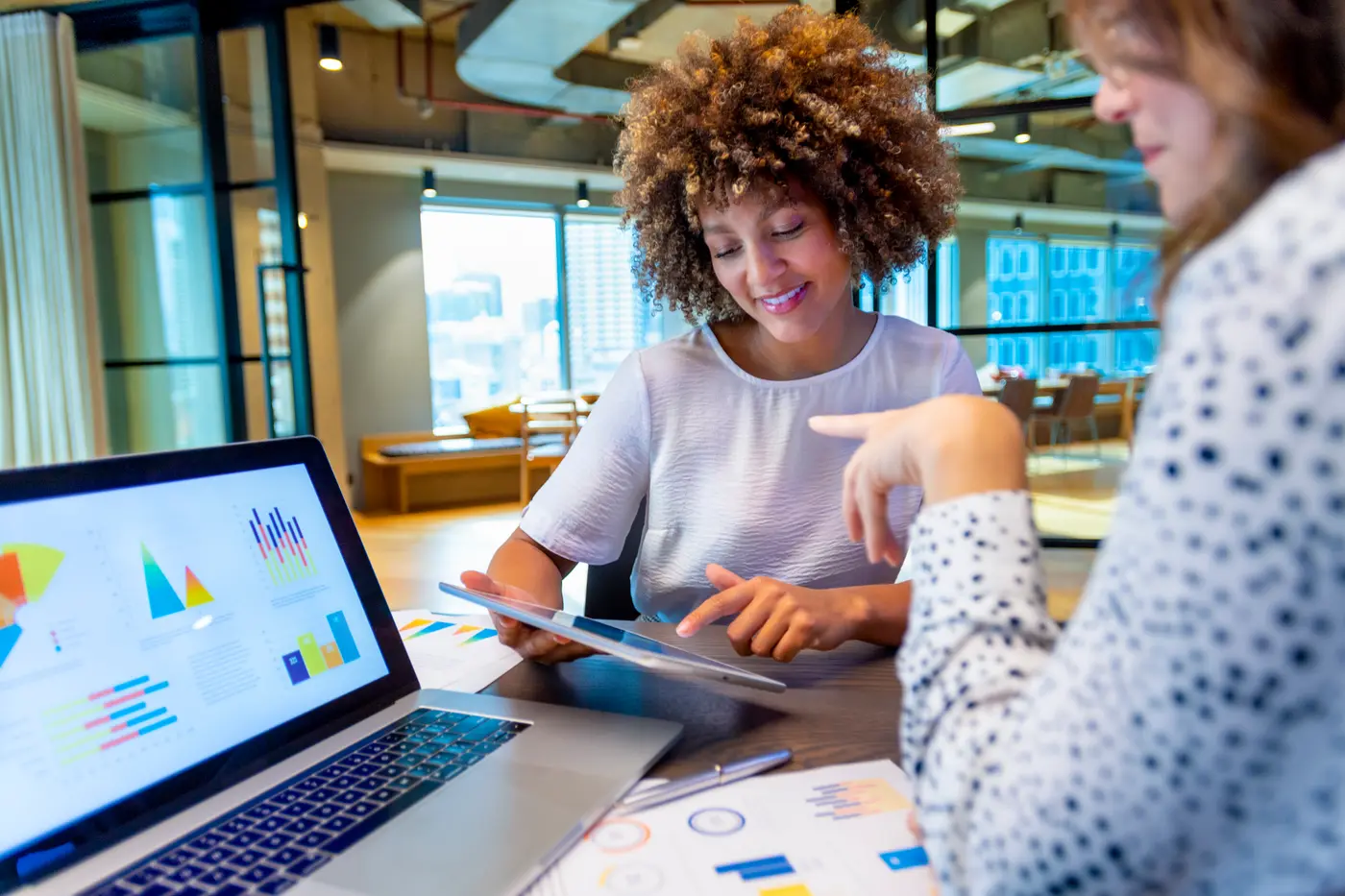 Business colleagues discussing finance charts and graphs on a laptop computer. 
