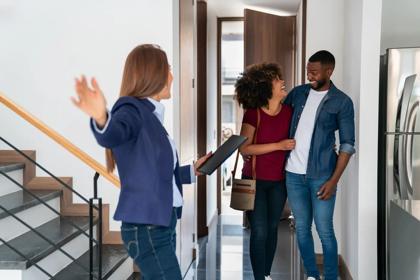 A property manager shows a happy couple their home.