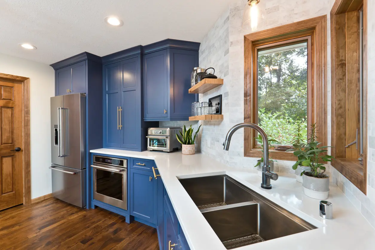 Contemporary blue kitchen with renovated windows, cabinets, and countertops. 