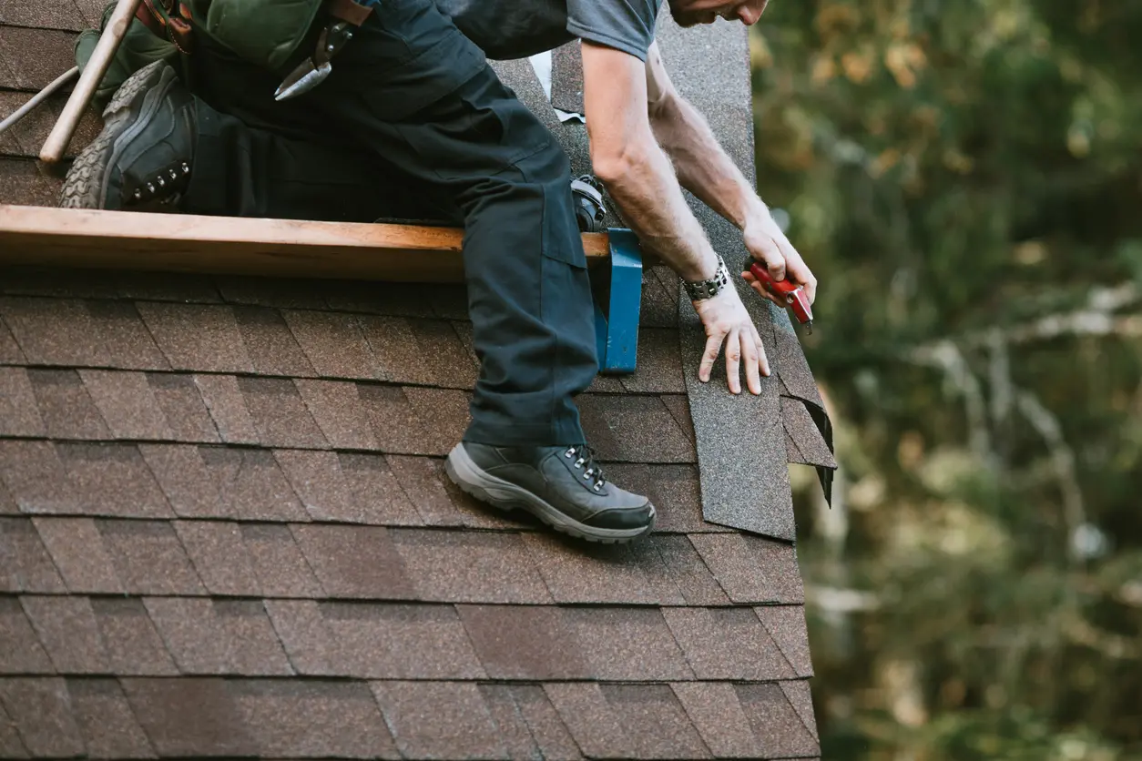 A person working on the roof of a house.