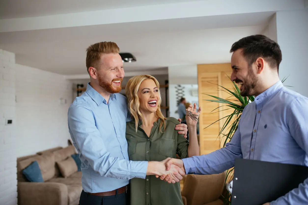 Happy Couple Closing A Great Deal on A House with Real Estate Agent