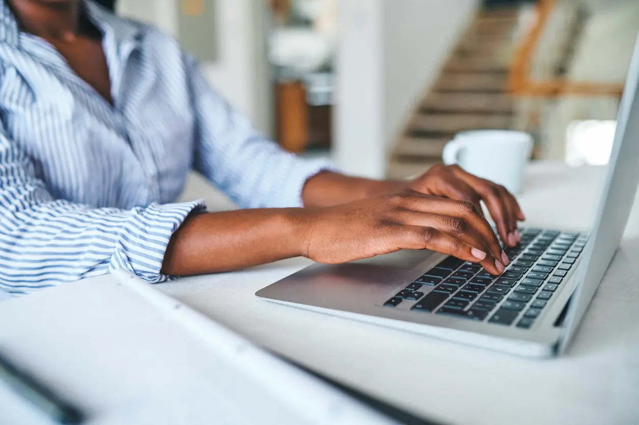 Closeup shot of a woman using a laptop at home