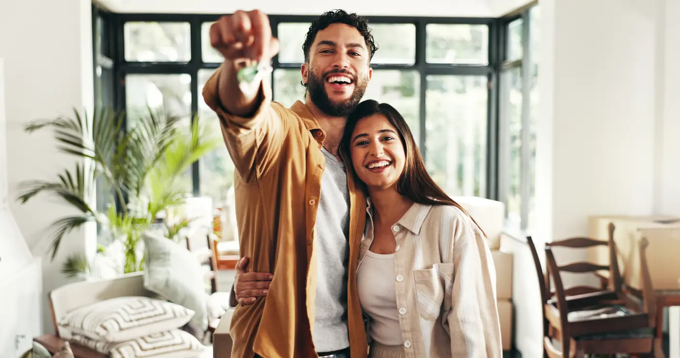 Key, happy and portrait of couple in new home with pride for property investment or real estate. Smile, confident and people from India with ownership for house with goal for buying apartment.