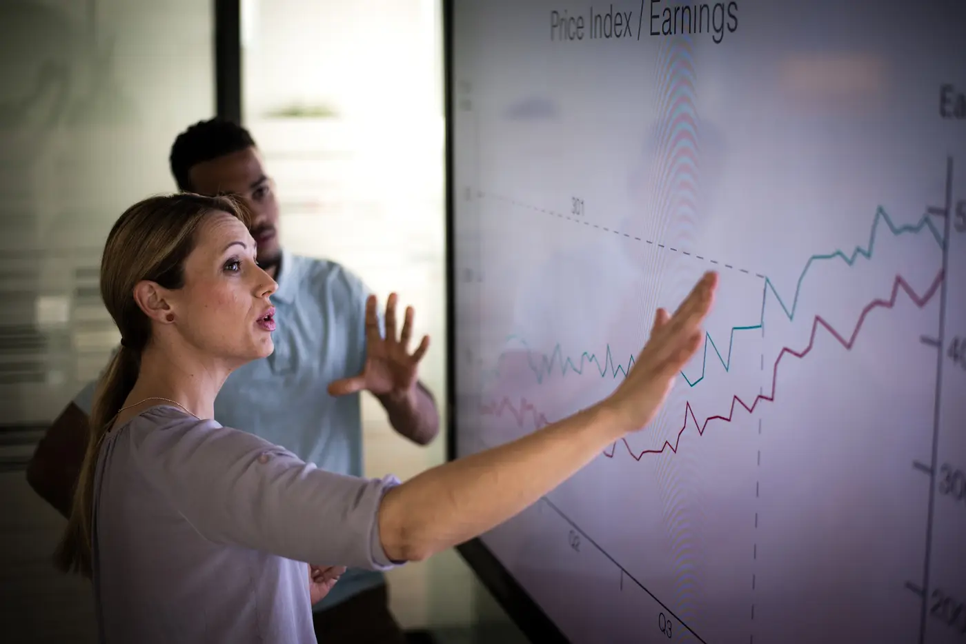 Business people discussing profits on a large screen